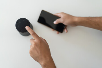 hands of a man connecting a phone with wireless speakers