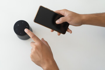 hands of a man connecting a phone with wireless speakers