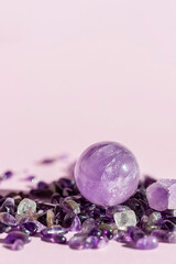 Crystal, mineral, transparent ball, sphere on a pink background.