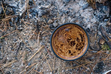 Thick coffee foam top view.  Visible bubbles and texture. Brewing coffee on the hearth. Forest soil background. Coffee with a pine smell. Copy space. 