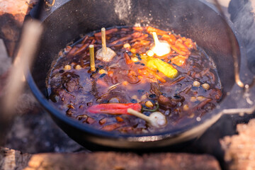 Preparation of raditional armenian pilaf in a cauldron on an open fire.