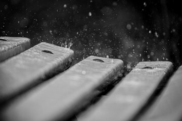 close-up de las gotas de lluvia sobre un banco del parque