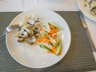 Plate of small muscles and marinated vegetables.