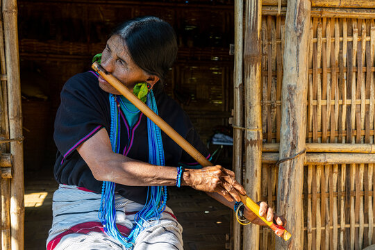 Chin woman with spiderweb tattoo blowing a flute with her nose, Kanpelet, Chin state
