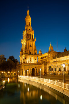 The North Tower of Plaza de Espana lit up at night, Parque de Maria Luisa, Seville, Andalusia, Spain