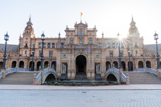A sun burst as it rises over the central building of Plaza de Espana, Parque de Maria Luisa, Seville, Andalusia, Spain