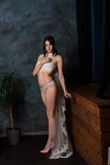 Beautiful bride in white lingerie sitting in her bedroom and studio.