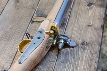 ancient weapons with an iron barrel and a wooden butt on an old table