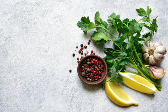 Culinary background with assortment of spices : lemon, garlic, pepper,parsley. Top view with copy space.