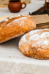 pair of fresh round breads lies on a table covered with a gray tablecloth vertical photo