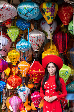 A young woman in traditional Vietnamese clothing standing outside a lantern shop, Hoi An, Vietnam, Indochina, Southeast Asia