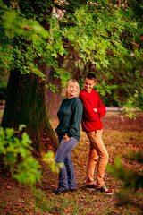 Naklejka na ściany i meble Beautiful woman,blonde,middle-aged,with a big son walking in the Park,a beautiful autumn day