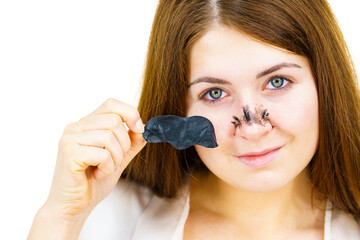 Woman removing pore strips mask from nose