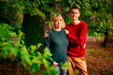 Beautiful woman,blonde,middle-aged,with a big son walking in the Park,a beautiful autumn day