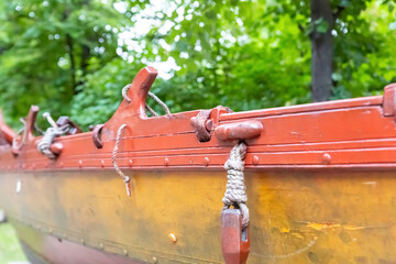 board of a wooden rowboat closeup background covered with yellow and red