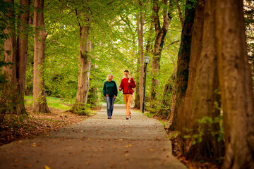 Fototapeta premium Beautiful woman,blonde,middle-aged,with a big son walking in the Park,a beautiful autumn day