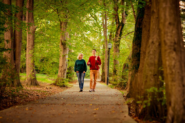 Obraz premium Beautiful woman,blonde,middle-aged,with a big son walking in the Park,a beautiful autumn day