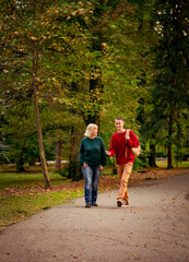 Fototapeta premium Beautiful woman,blonde,middle-aged,with a big son walking in the Park,a beautiful autumn day