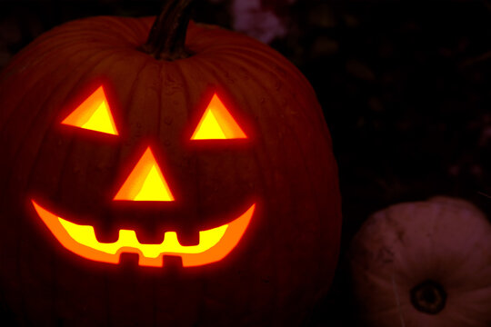 burning smile carved mask of halloween pumpkins terrifying face out of the dark