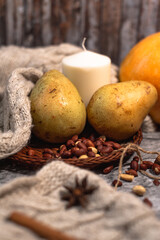 Fototapeta na wymiar cozy autumn. candle, cinnamon, pear, anise, nuts on white knitted sweater. Hygge lifestyle.