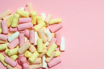 Marshmallows on pink background with copyspace. Flat lay or top view. Background or texture of colorful mini marshmallows.
