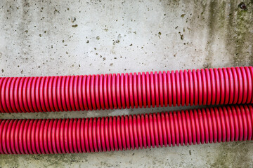 two plastic red pipes near the road on the construction