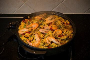 Paella traditional Spanish food. Paella with with mussels, king prawns, langoustine and squids. Person cooking paella.Family dinner.