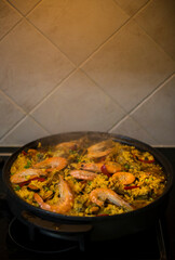 Paella traditional Spanish food. Paella with with mussels, king prawns, langoustine and squids. Person cooking paella.Family dinner.