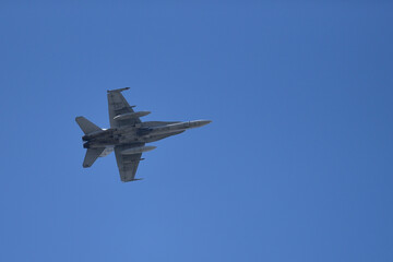 Fototapeta na wymiar Military jet flying on a blue sky