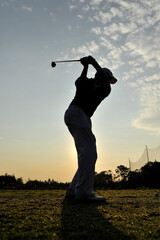 silhouette of a golfer practicing