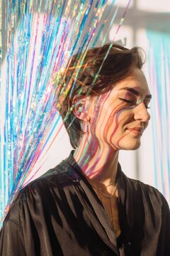 Daydreaming pretty woman among shining tinsel