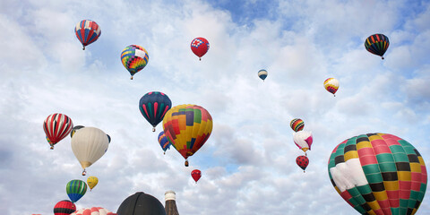 One hot air balloon takes the lead rising among a flurry of other balloons