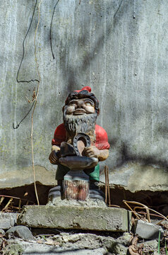 A fabulous dwarf holds a horseshoe in his hands. Concept: amulet and luck.