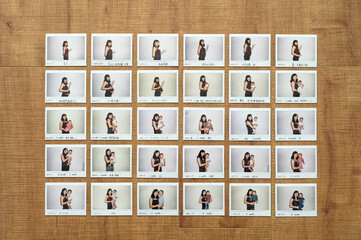 Overhead view of Instant photos of mother and her daughter on wood floor