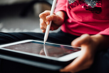Cute girl studying with tablet for education and touch pen