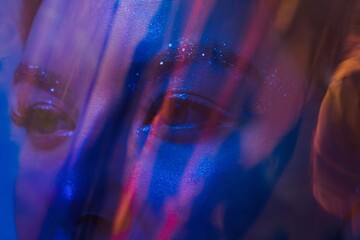 Woman eyes behind blue shining plastic