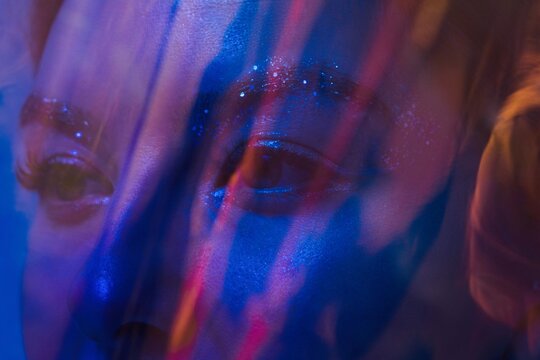 Woman eyes behind blue shining plastic