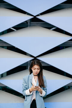 Young and fashionable asian girl using smartphone in downtown