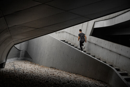 Male runner runs in a concrete architecture