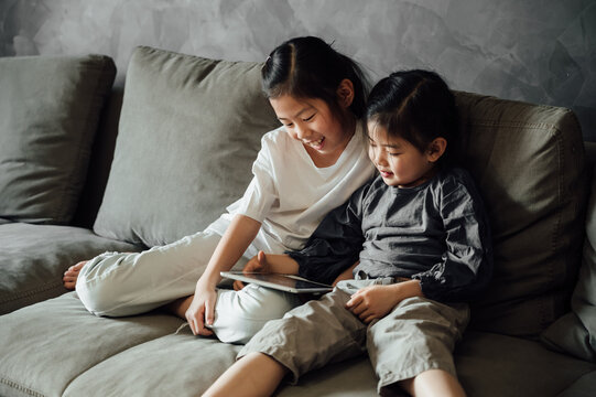 Cute little girls using tablet at home