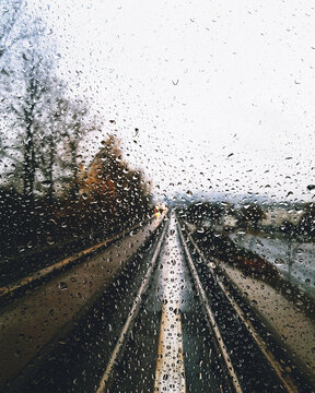 Train tracks as seen through a rain-drenched glass window.
