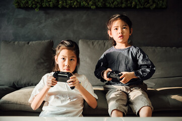 Cute little girls playing video games at home