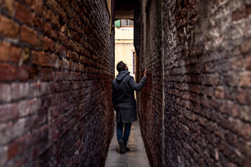 Man walking in a small alley during a trip in Venice, Italy