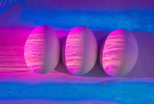 White chicken eggs under neon lights