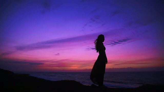 Silhouette of beautiful girl / woman at the sunset monment by the sea, Kaena Point, North Shore, Oahu, Hawaii