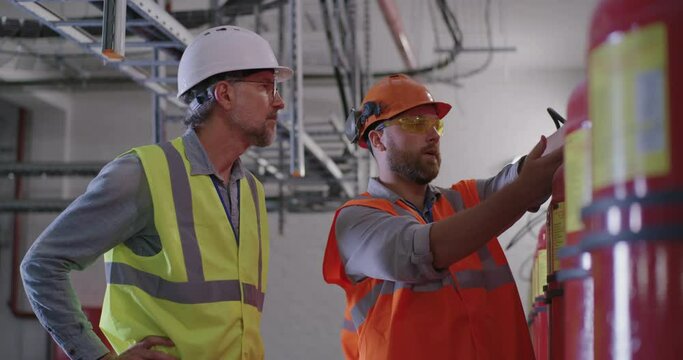 Engineers examining fire extinguishers on power plant