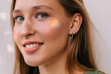 Woman with small rainbow on her face