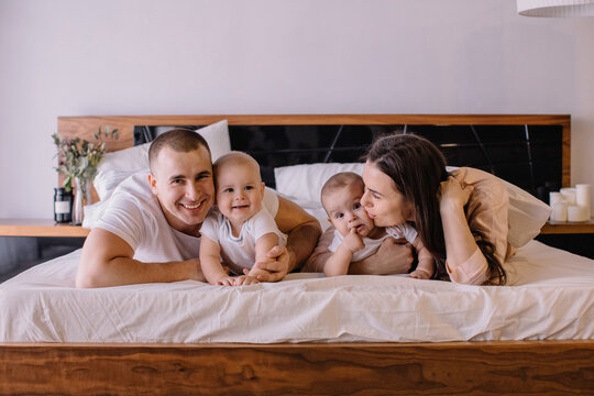 Young family with little twins in bed