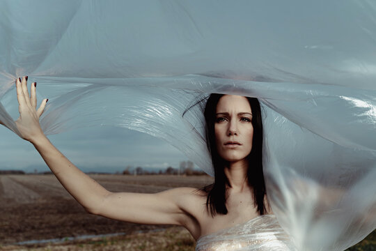Woman in nature covered with plastic. Plastic problem