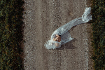 Aerial view of a woman in nature covered with plastic. Plastic concept